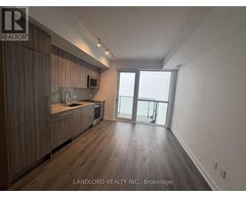 A spacious kitchen with wooden cabinets and a large window.