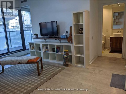 A living room with a television and a bench.