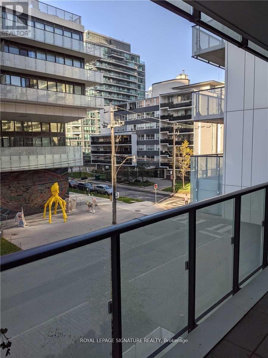 A view from a balcony overlooking a city street with modern buildings.
