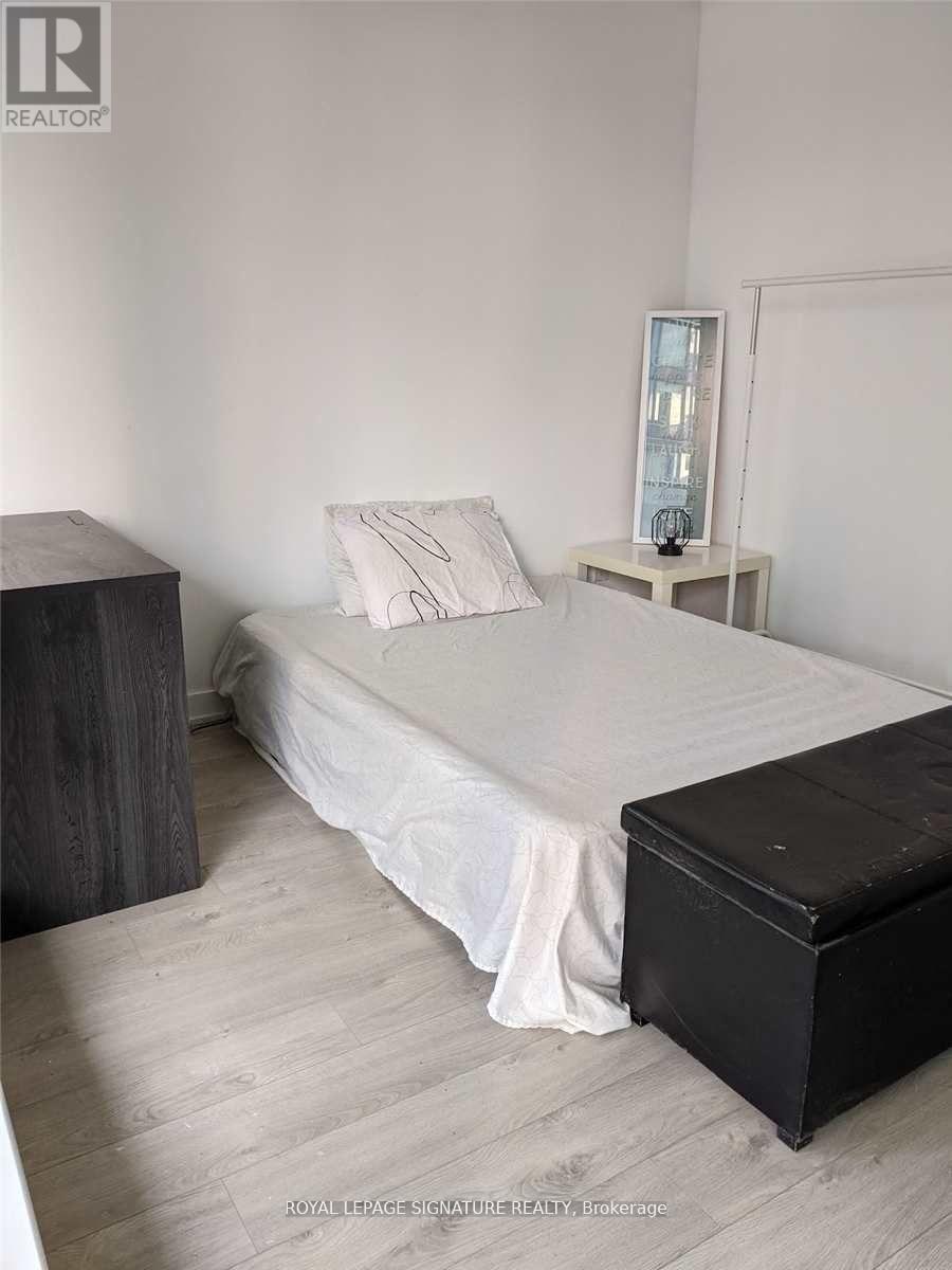 A bedroom with a bed, a nightstand, and a wooden side table.