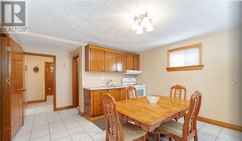 A dining room with a wooden table and chairs.