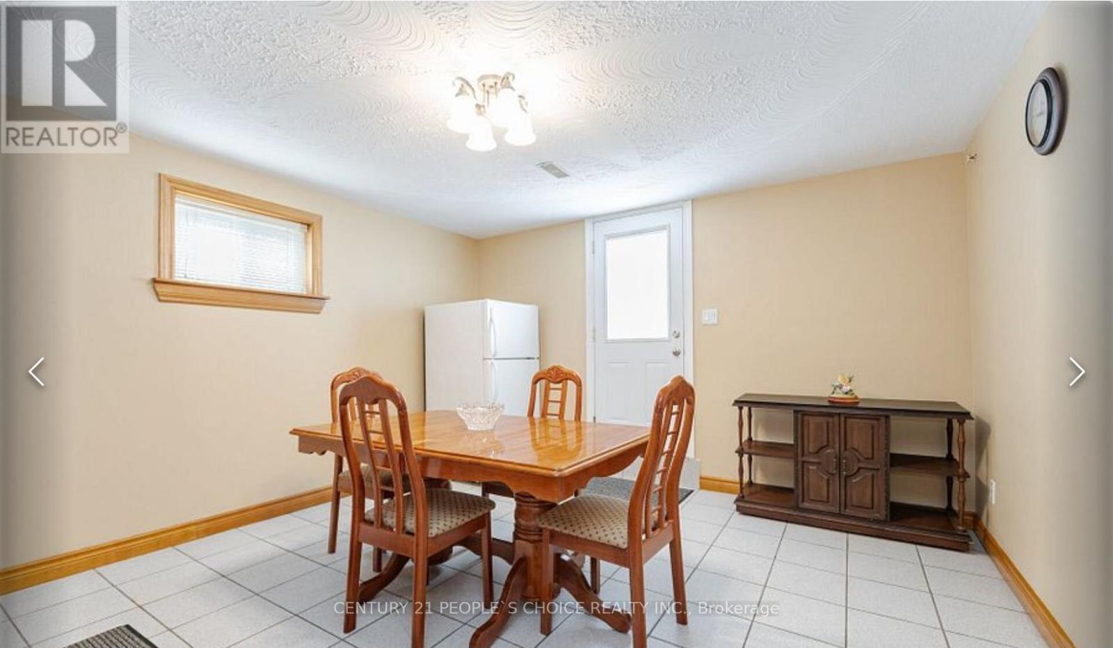 A dining room with a wooden table and chairs.