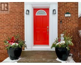 A red door with a snowman decoration in front of it.