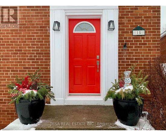A red door with a snowman decoration in front of it.
