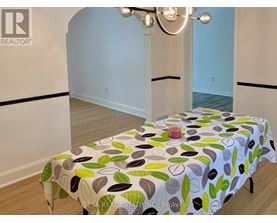 A bedroom with a bed covered in a leaf-patterned bedspread.