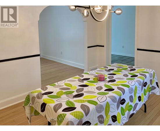 A bedroom with a bed covered in a leaf-patterned bedspread.