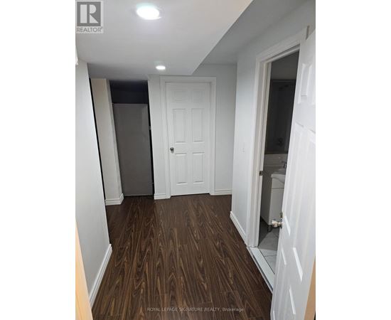 A hallway with a white door and a white wall.