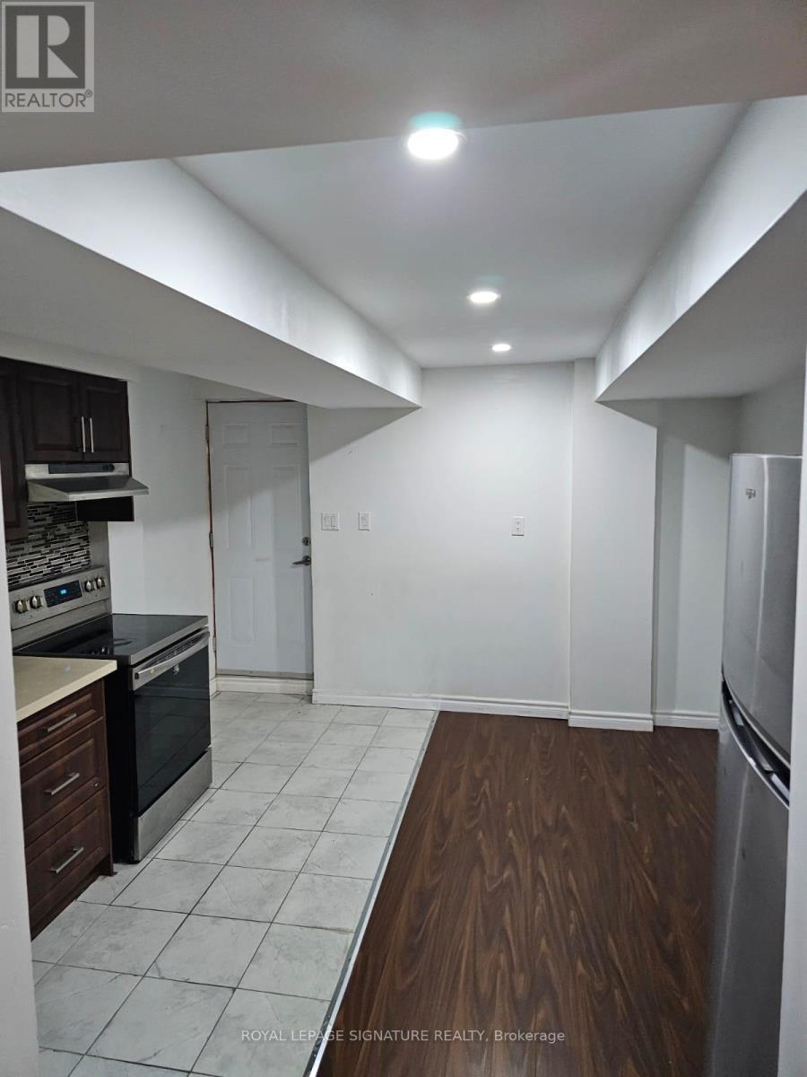 A kitchen with white walls and a wooden floor.