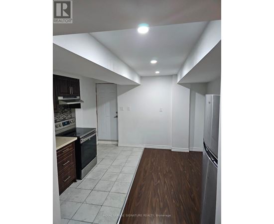 A kitchen with white walls and a wooden floor.