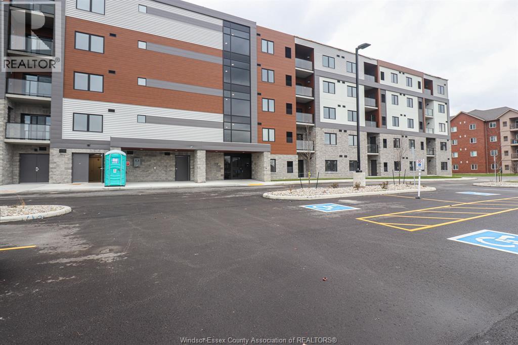 A parking lot in front of a multi-story apartment building.