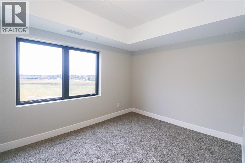 A room with a large window and carpeted floor.