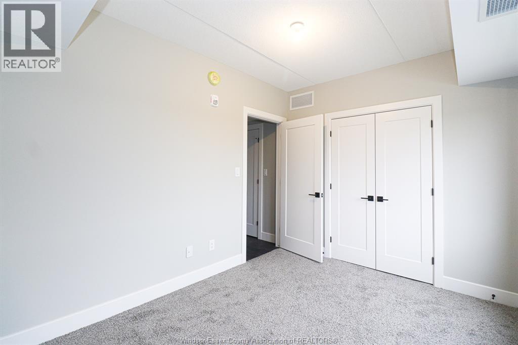 A room with white walls and a grey carpet.