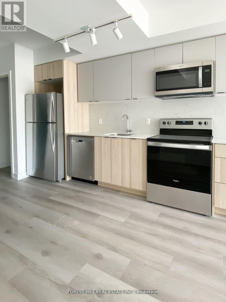 A modern kitchen with a refrigerator, oven, and microwave.