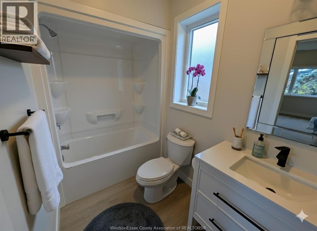 A bathroom with a toilet, sink, and bathtub.