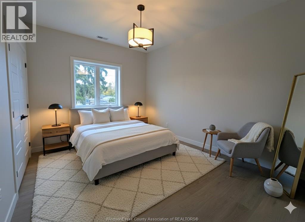 A bedroom with a large bed, a chair, and a window.