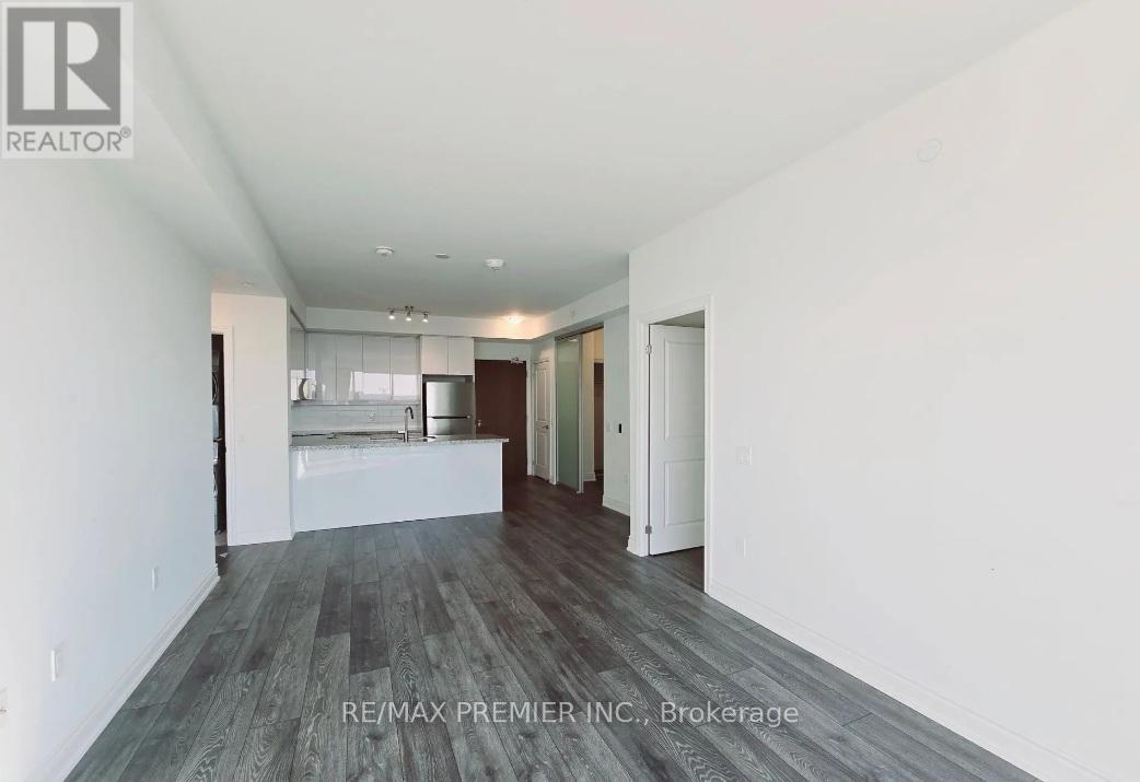 A spacious room with wooden flooring and white walls, part of a RE/MAX Premier Inc. property in Brokerage.