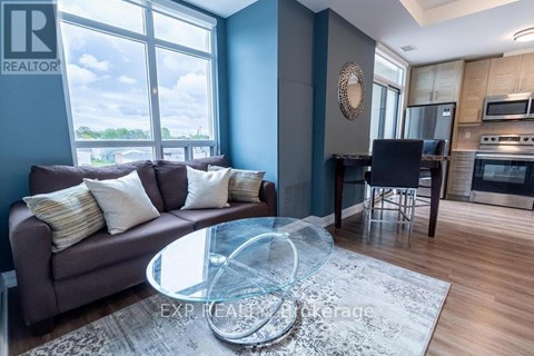 A living room with a grey couch and a glass coffee table.