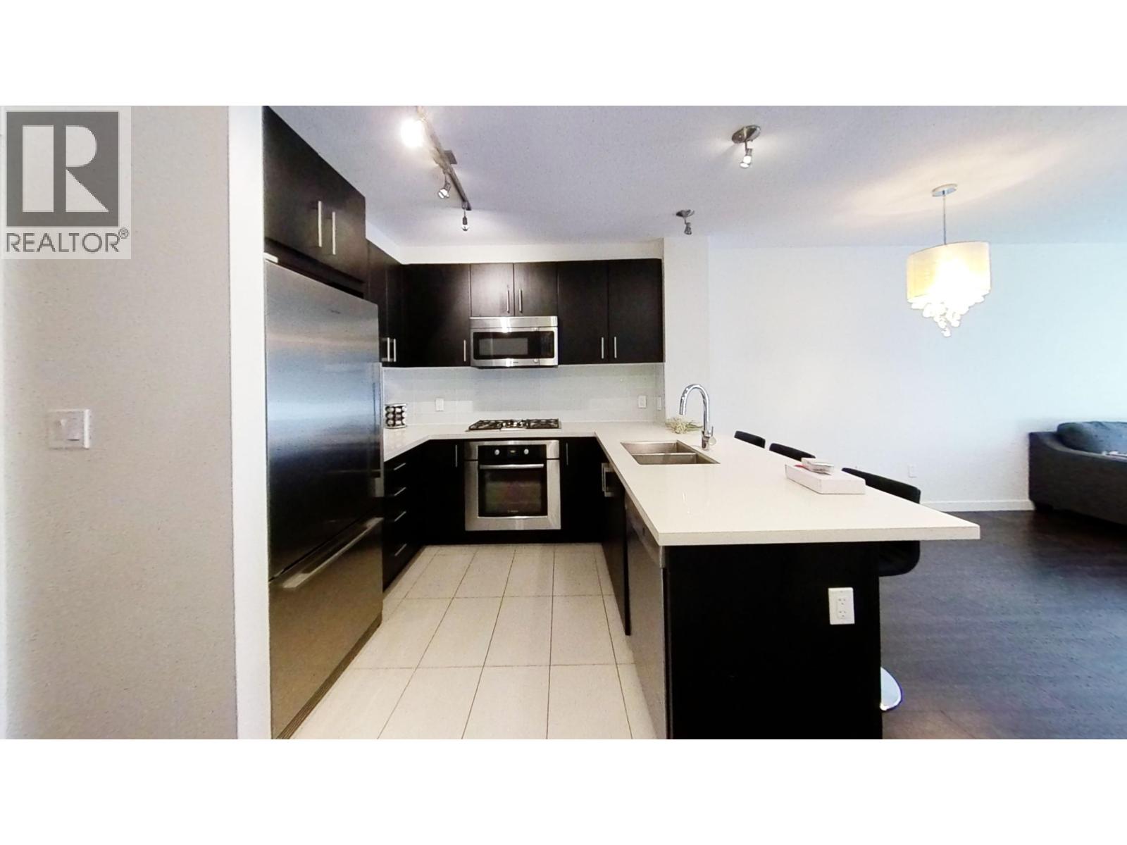 A modern kitchen with a white countertop and black cabinets.