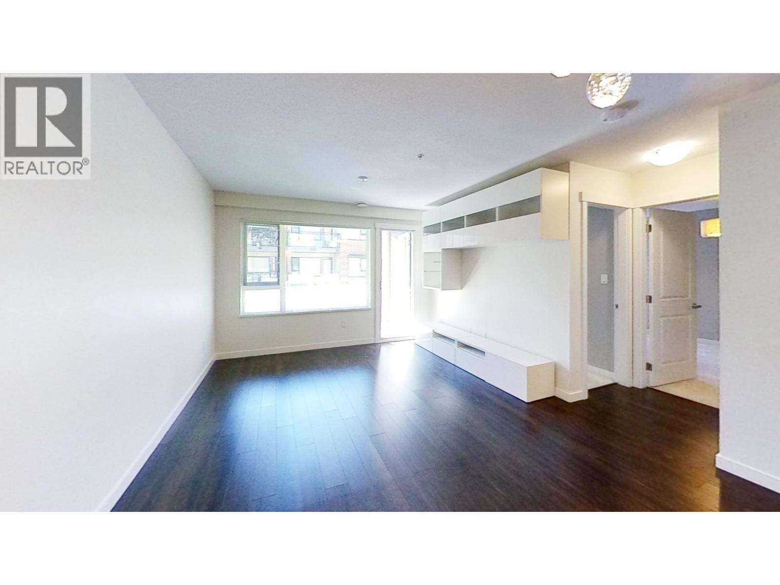 A large empty room with a window and a door.