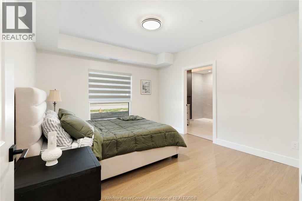 A bedroom with a bed, nightstand, and lamp.