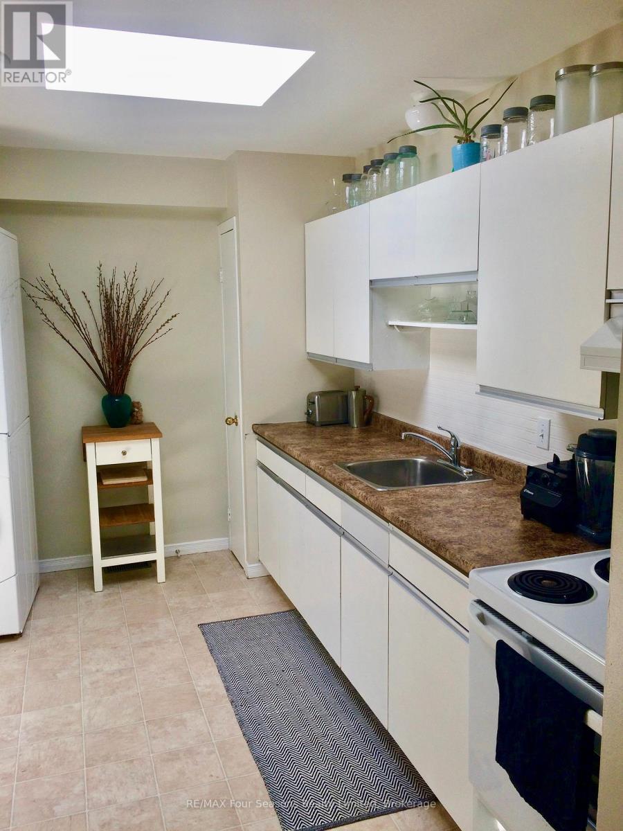 A kitchen with white cabinets and a brown countertop.