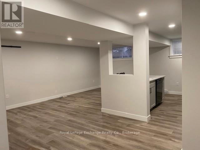 A spacious room with wooden flooring and a television mounted on the wall.