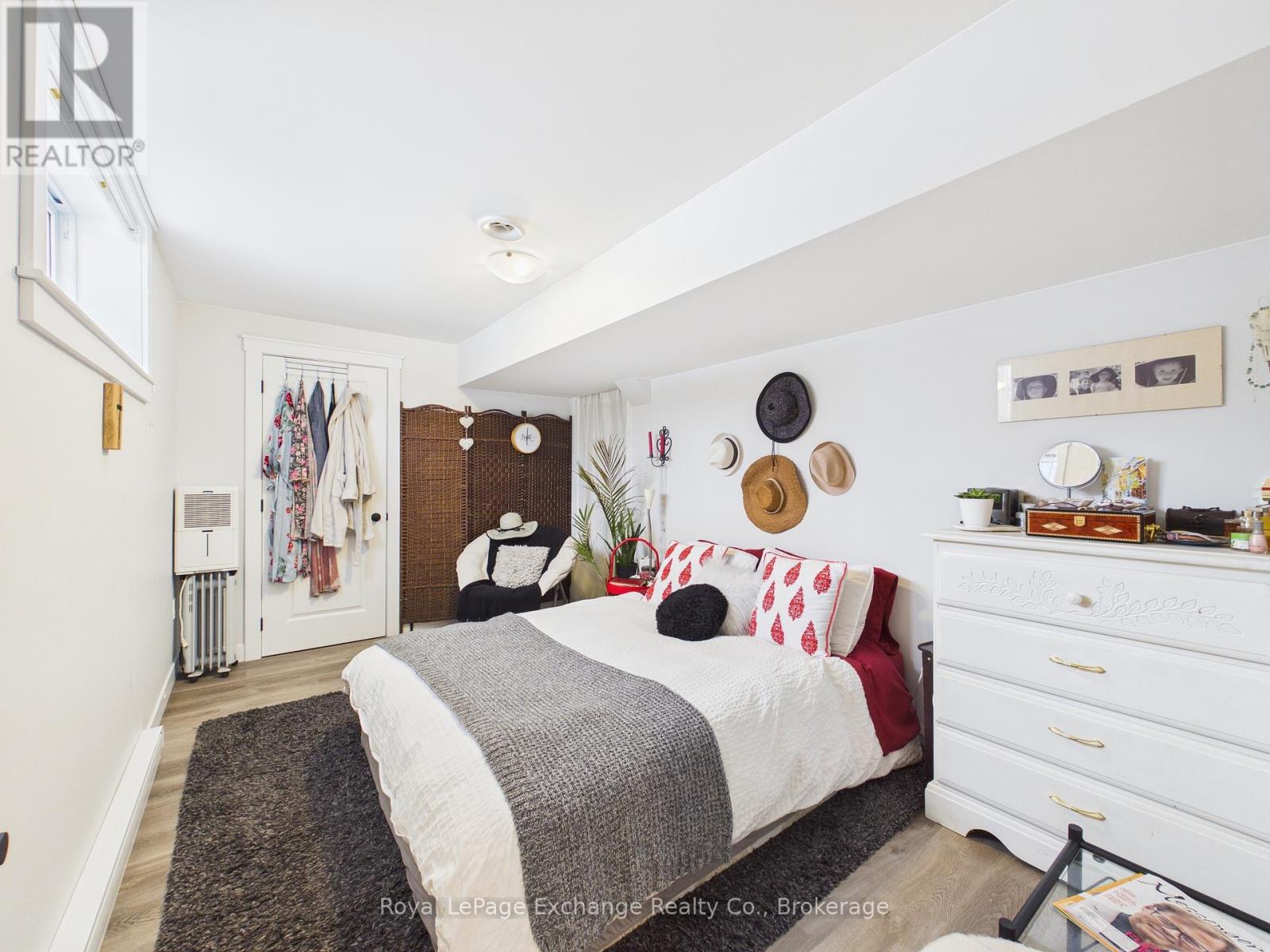A bedroom with a bed, dresser, and mirror.