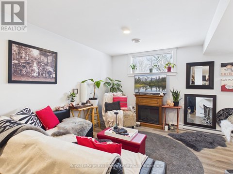 A living room with a couch, a fireplace, and a painting on the wall.