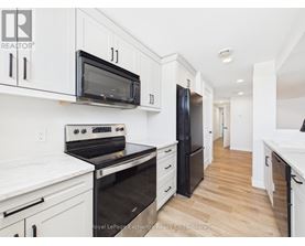 A kitchen with white cabinets and a white island with bar stools.