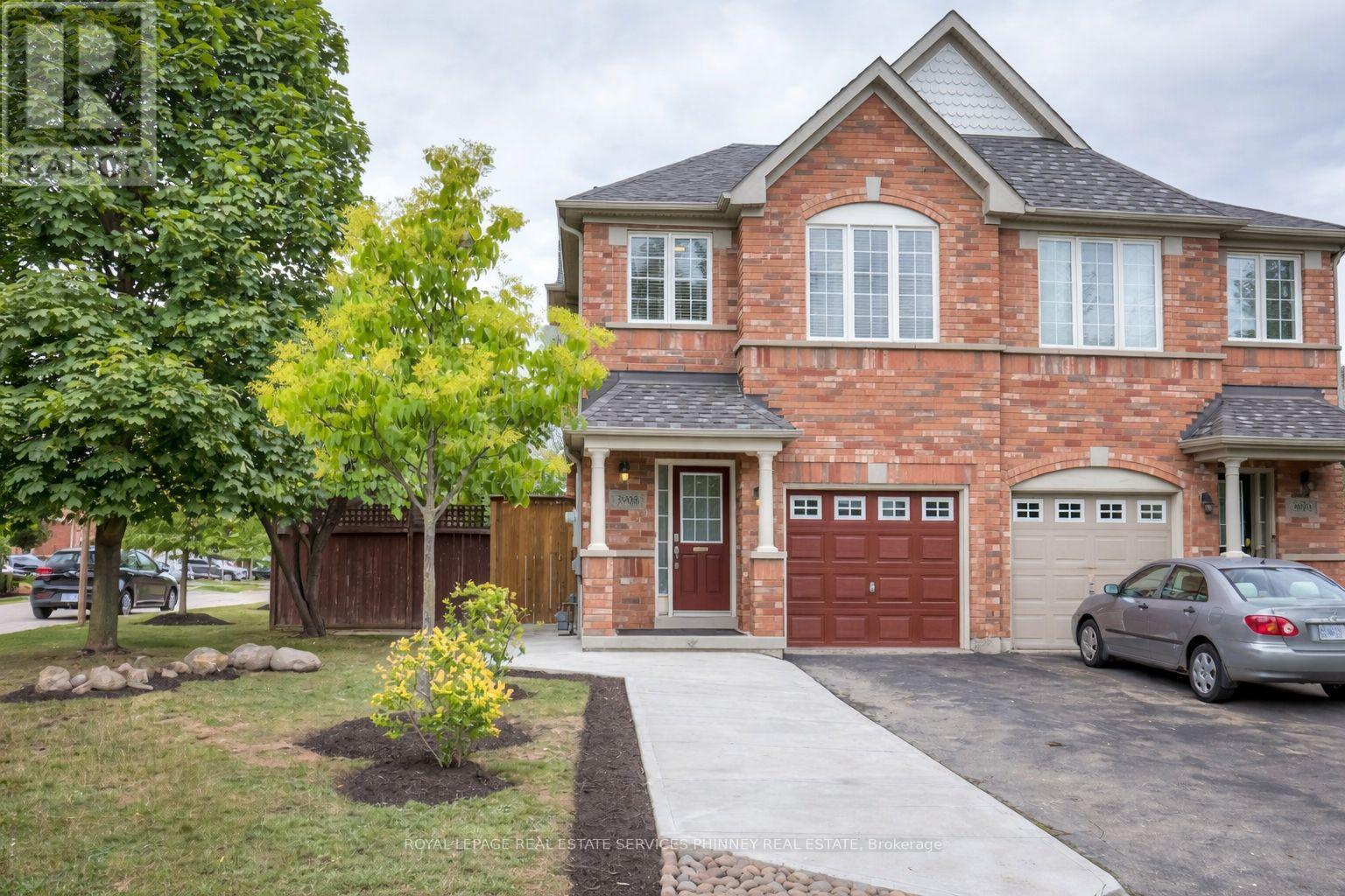 A brick house with a red door and a garage door.