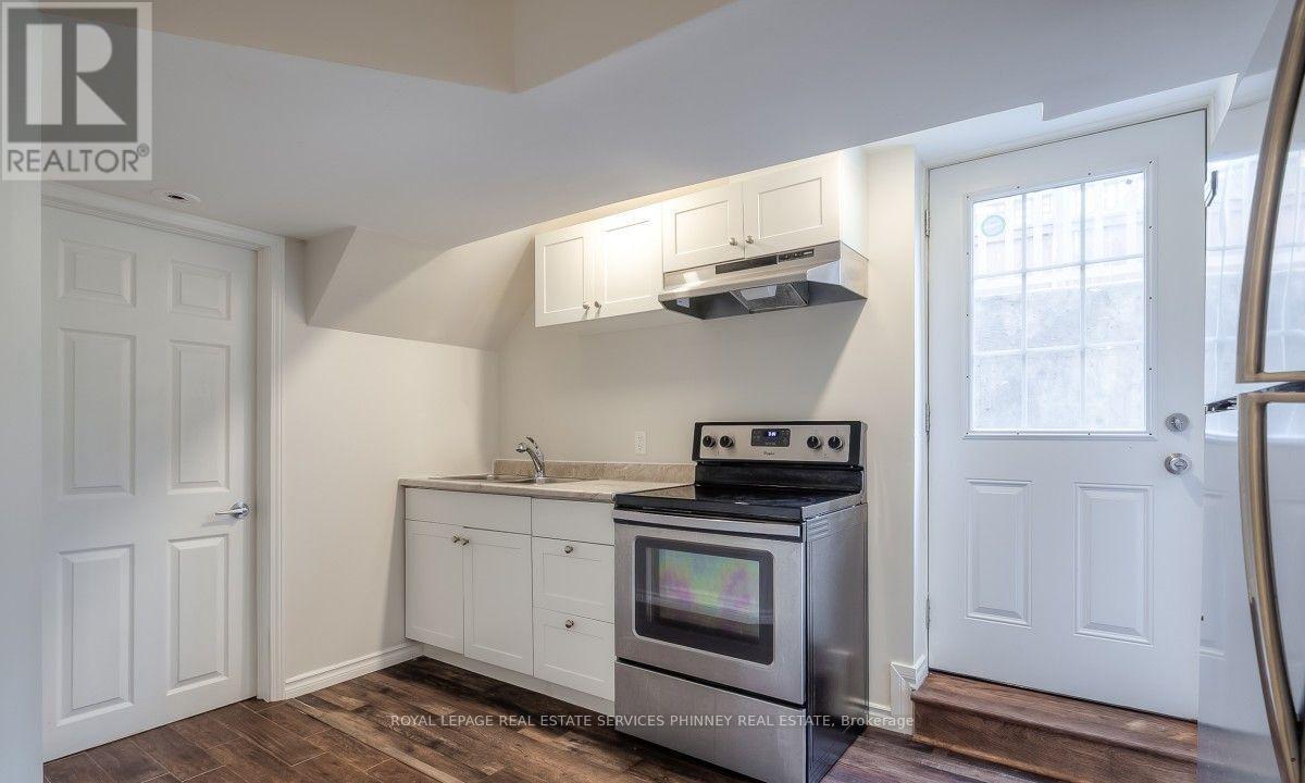 A kitchen with a stove top oven and a sink.
