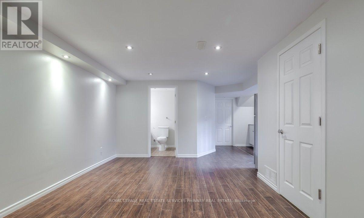 A spacious room with wooden floors and white walls.