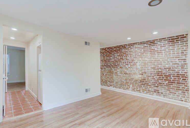 A room with a brick wall and wooden flooring.