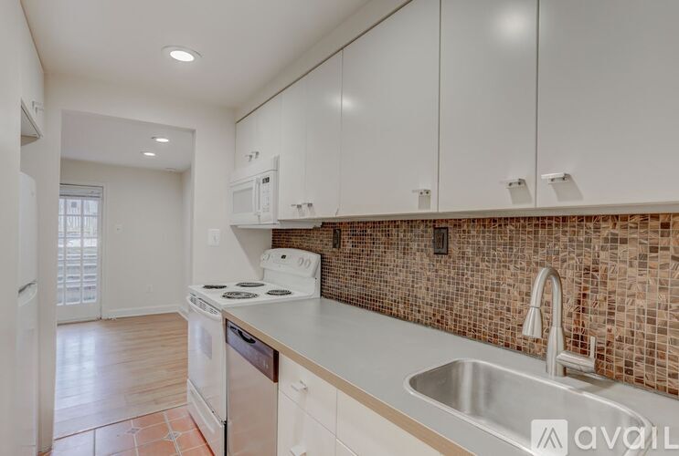 A kitchen with white cabinets and a tiled backsplash.