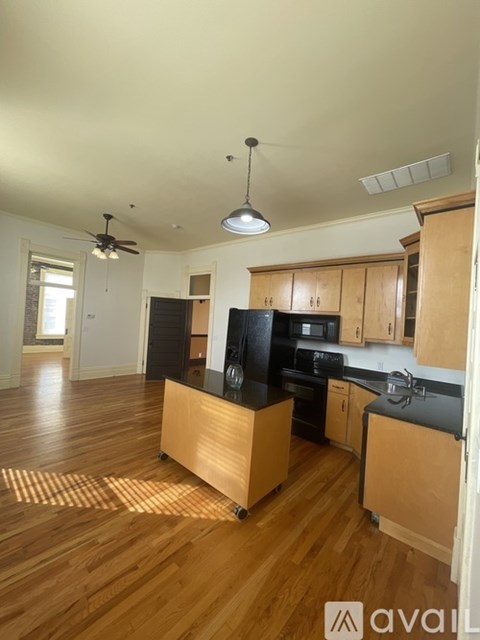 A kitchen with wooden cabinets and black appliances.