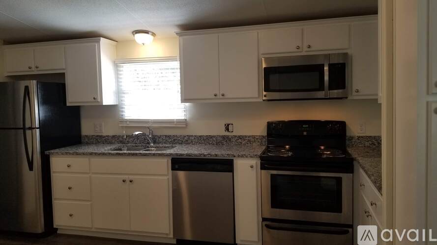 A kitchen with black appliances and white cabinets.
