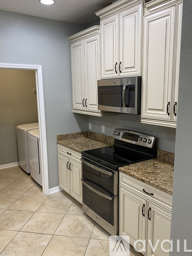A kitchen with white cabinets and granite countertops.