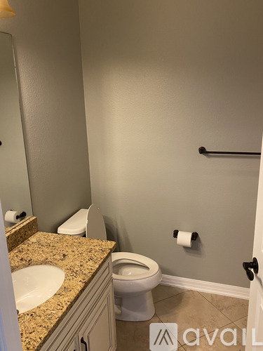 A bathroom with a toilet, sink, and mirror.