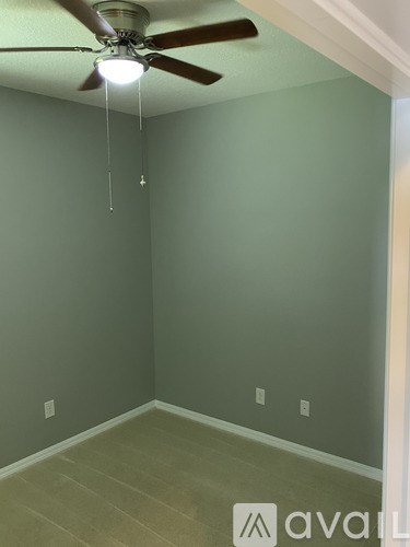 A room with a ceiling fan and light fixture.