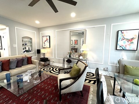 A living room with a glass table and a sofa.