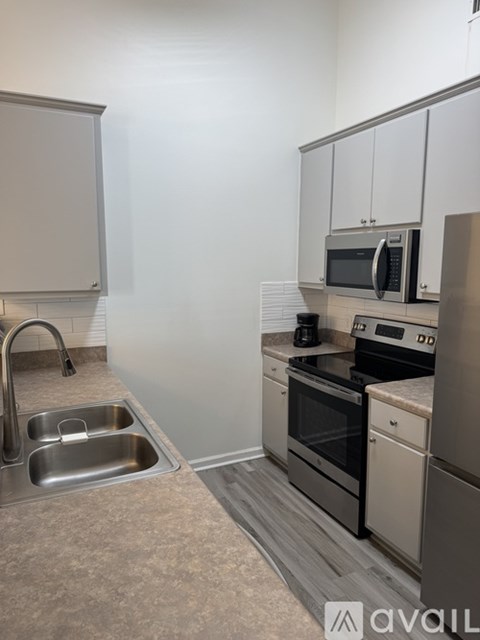 A kitchen with a sink, stove, and refrigerator.