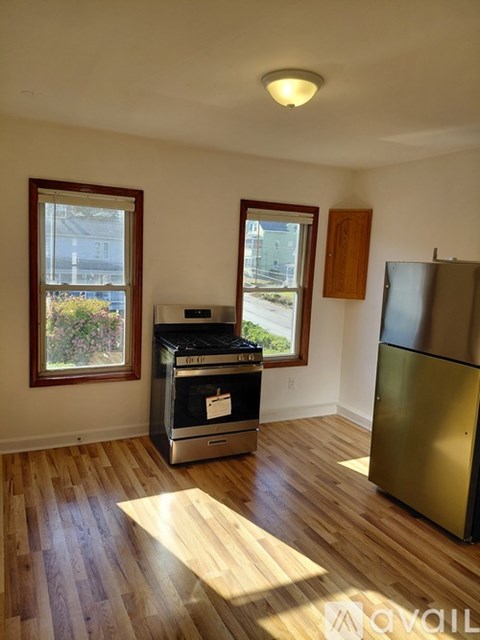 A kitchen with a stainless steel refrigerator and a stove with an oven.
