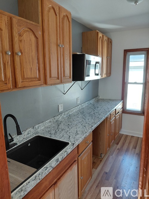 A kitchen with wooden cabinets and granite countertops.