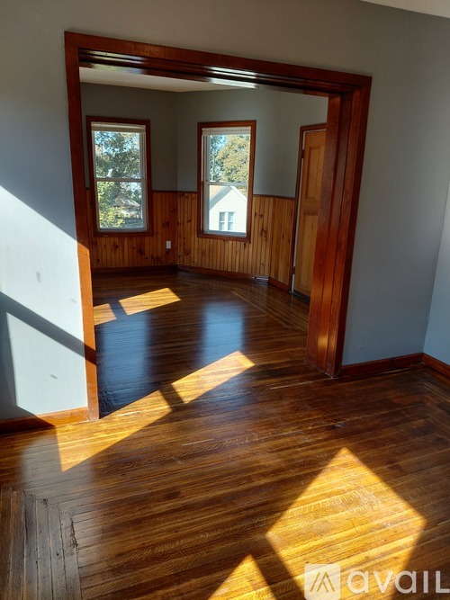A room with wooden floors and a large mirror on the wall.