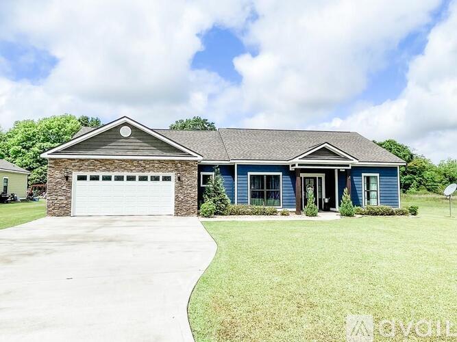 A house with a blue garage door and a white driveway.