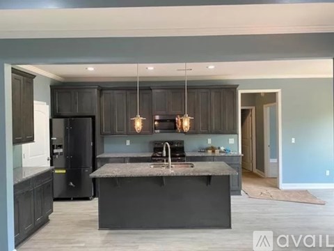 A modern kitchen with dark wood cabinets and a granite countertop.