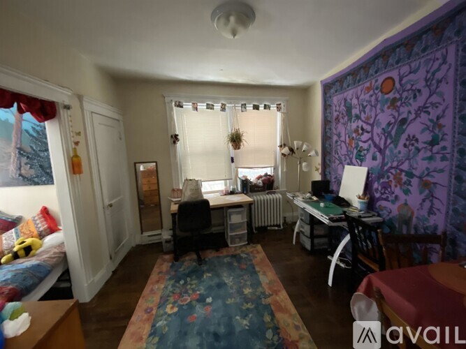 A room with a bed, desk, and chair.