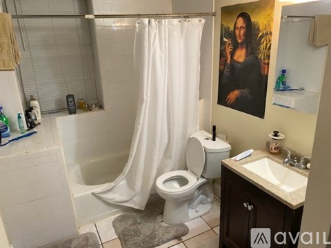 A bathroom with a Mona Lisa painting on the wall.