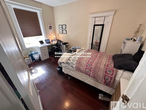 A bedroom with a bed, desk, and chair.