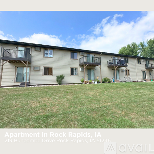 Apartment building with balconies and a lawn in front.